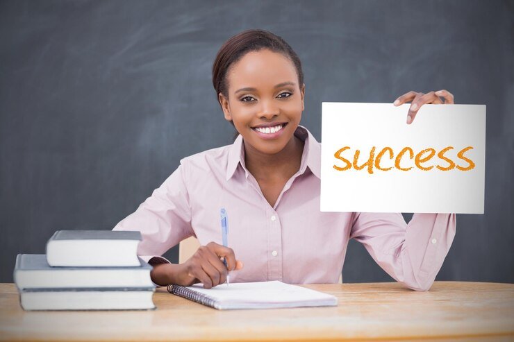 happy-teacher-holding-page-showing-success-her-classroom-school_1134-78772